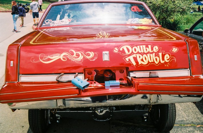 A red lowrider with 'Double Trouble' airbrushed.