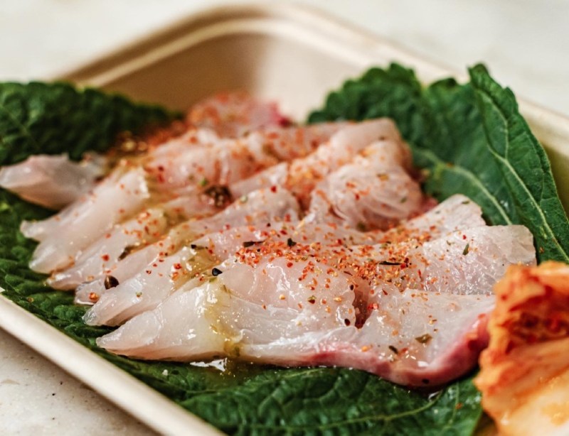 Sashimi cut fish on a green leaf