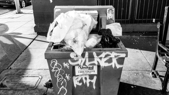 hand-washing station completely covered in trash.