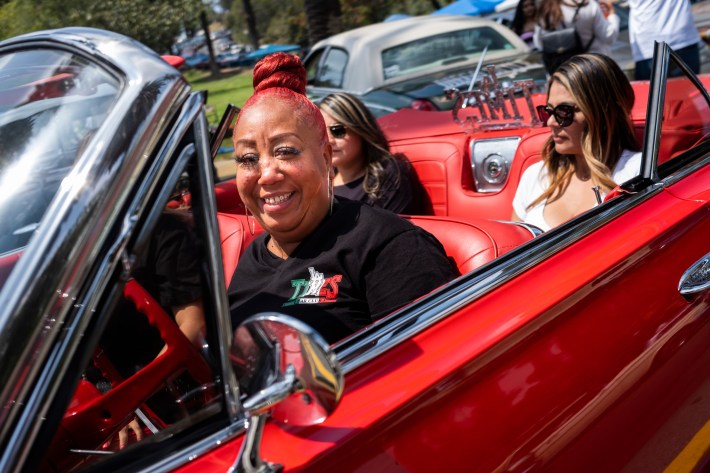 A woman smiles in her lowrider. Photo by Brian Feinzimer for L.A. TACO.