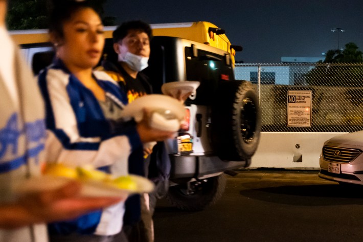 Patrons of Ave 26 Tacos walk with food on Humboldt Street adjacent to the closure of Artesian Place near Ave. 26 in Northeast Los Angeles, CA on August 6, 2021. (Brian Feinzimer)