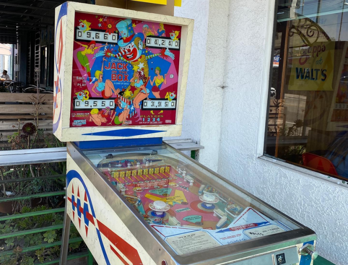 A clown jack-in-the-box-themed pinball machine at Walt's Bar.