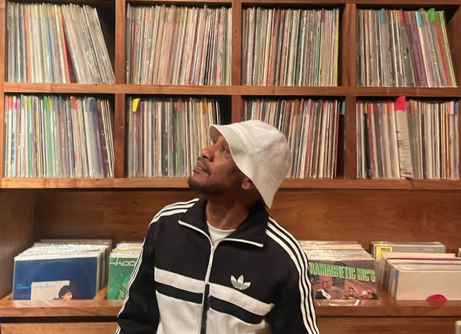 DJ Prince Paul at Gold Line Bar, looking up at the records.
