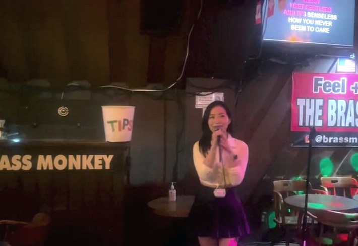 A woman singing karaoke at Cafe Brass Monkey.