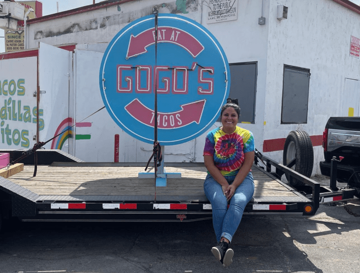 Brittney Valles of Gogo's Tacos sitting in front of her now closed taquería. Photo via L.A. TACO archives.