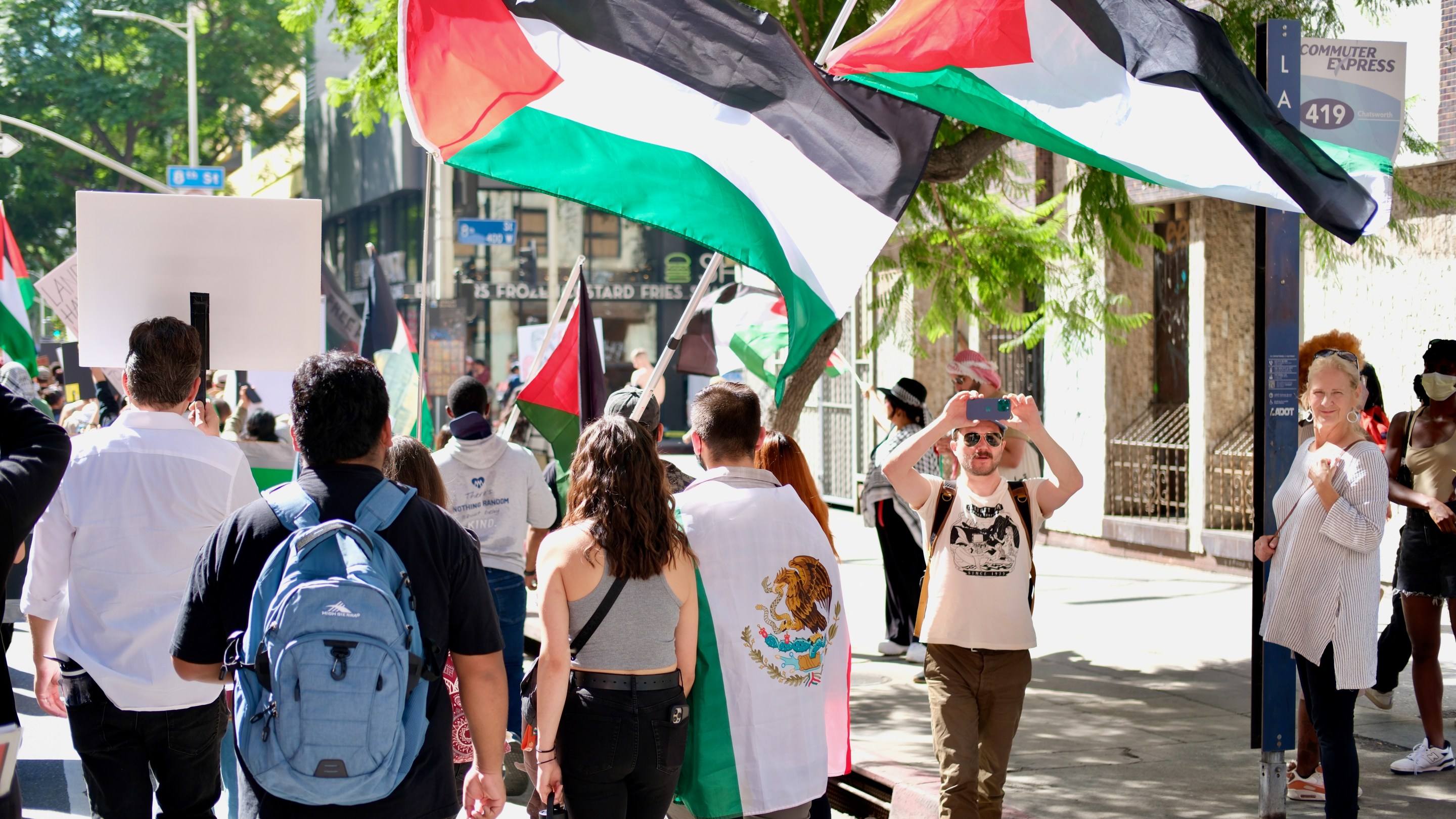 protestors carrying two Palestinian flags