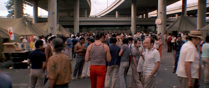 Manny (center) looks for Tony in a sea of people at Freedomtown in the movie ScarfaceScreenshot via Universal Pictures
