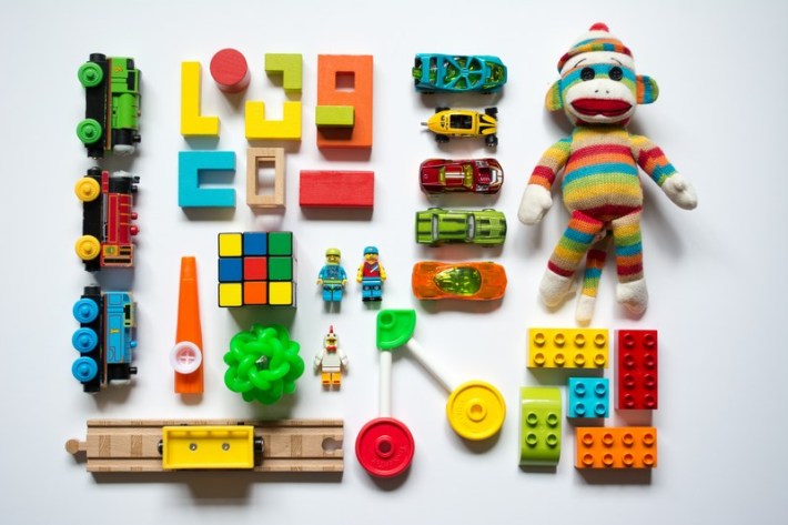 A collection of colorful toys, including toy racecars and a sock monkey