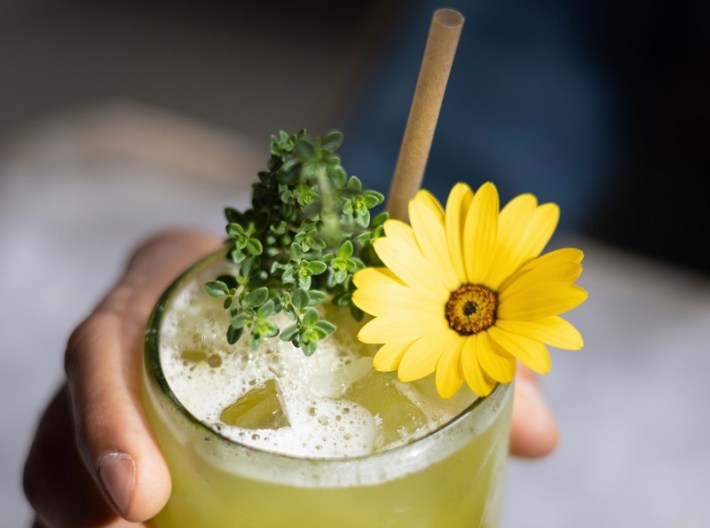 A mocktail topped with a yellow flower from Meteora