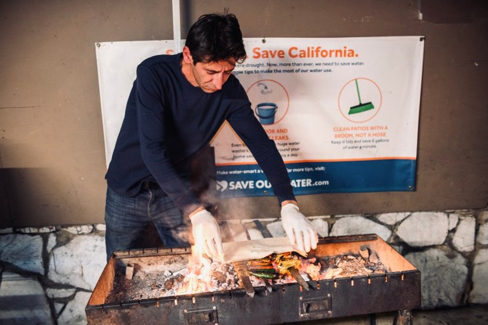 Hussein Akbar cooking kebabs over a charcoal grill