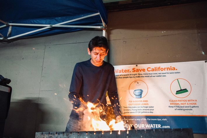 Hussein Akbar cooking kebabs over a charcoal grill