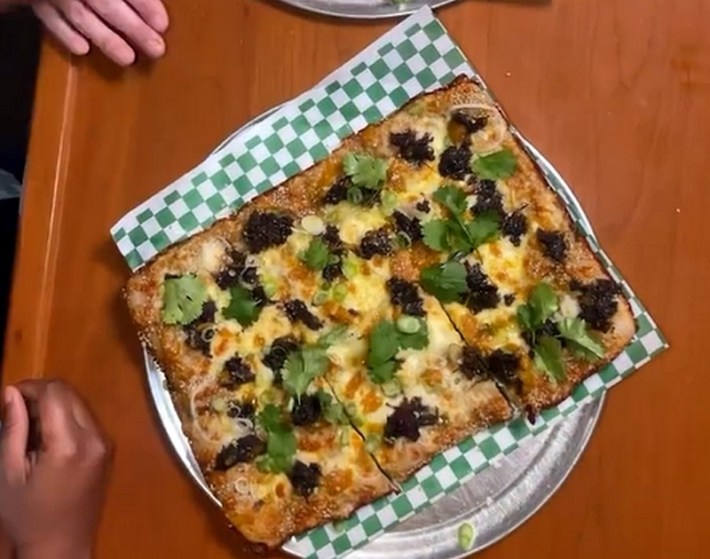 A square pizza with curry oxtail from Bridgetown Roti and Quarter Sheets Pizza