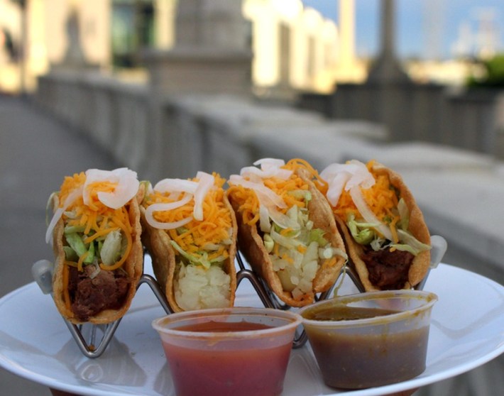 Four tacos dorados in taco holders from Chuy's Tacos Dorados