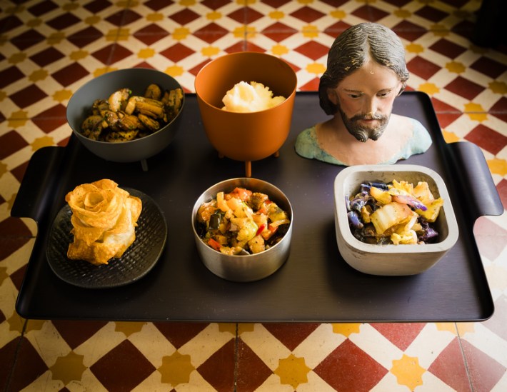 Food served at Zozo in L.A., featuring a bust of Jesus next to five dishes