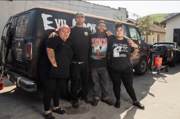 Four chefs and owners of EVIL Cooks standing in front of their black van