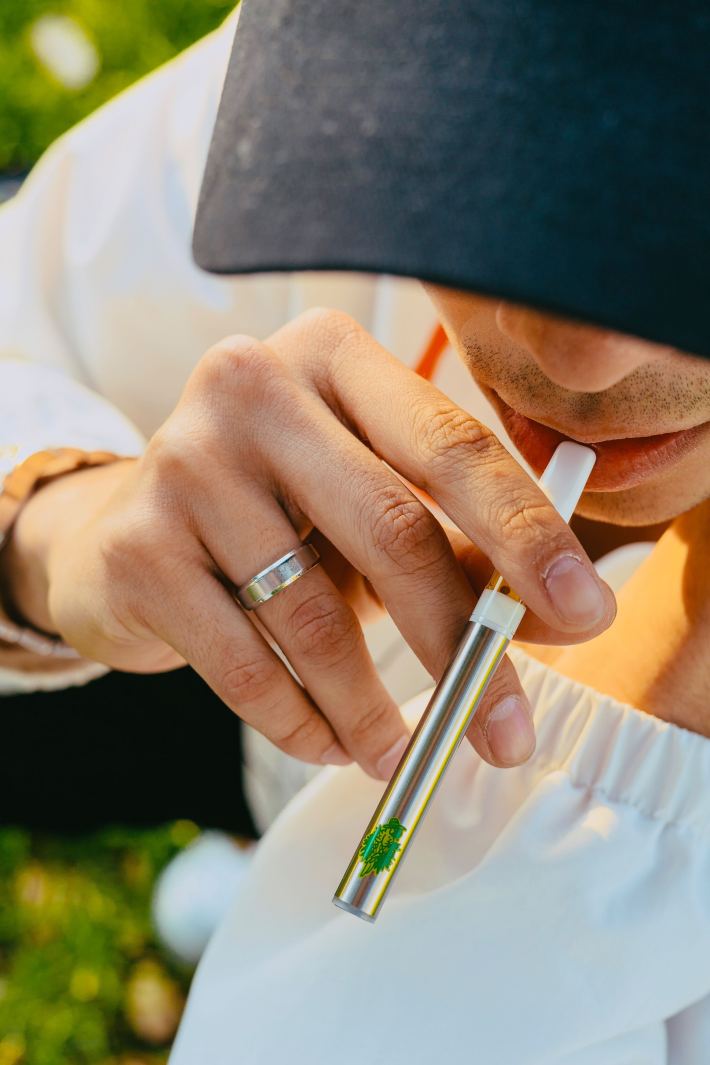 A person in a cap hitting a vape pen