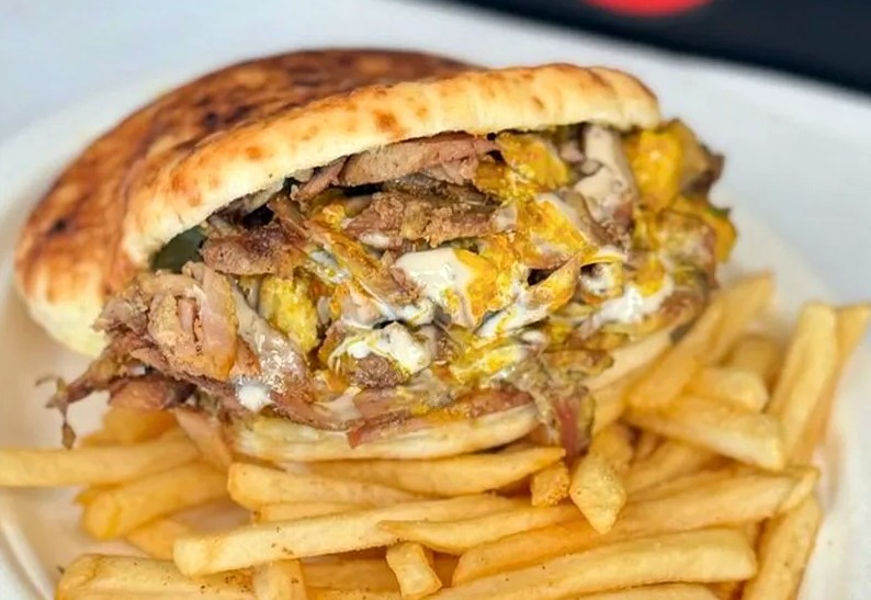 A shawarma sandwich on a bed of fries