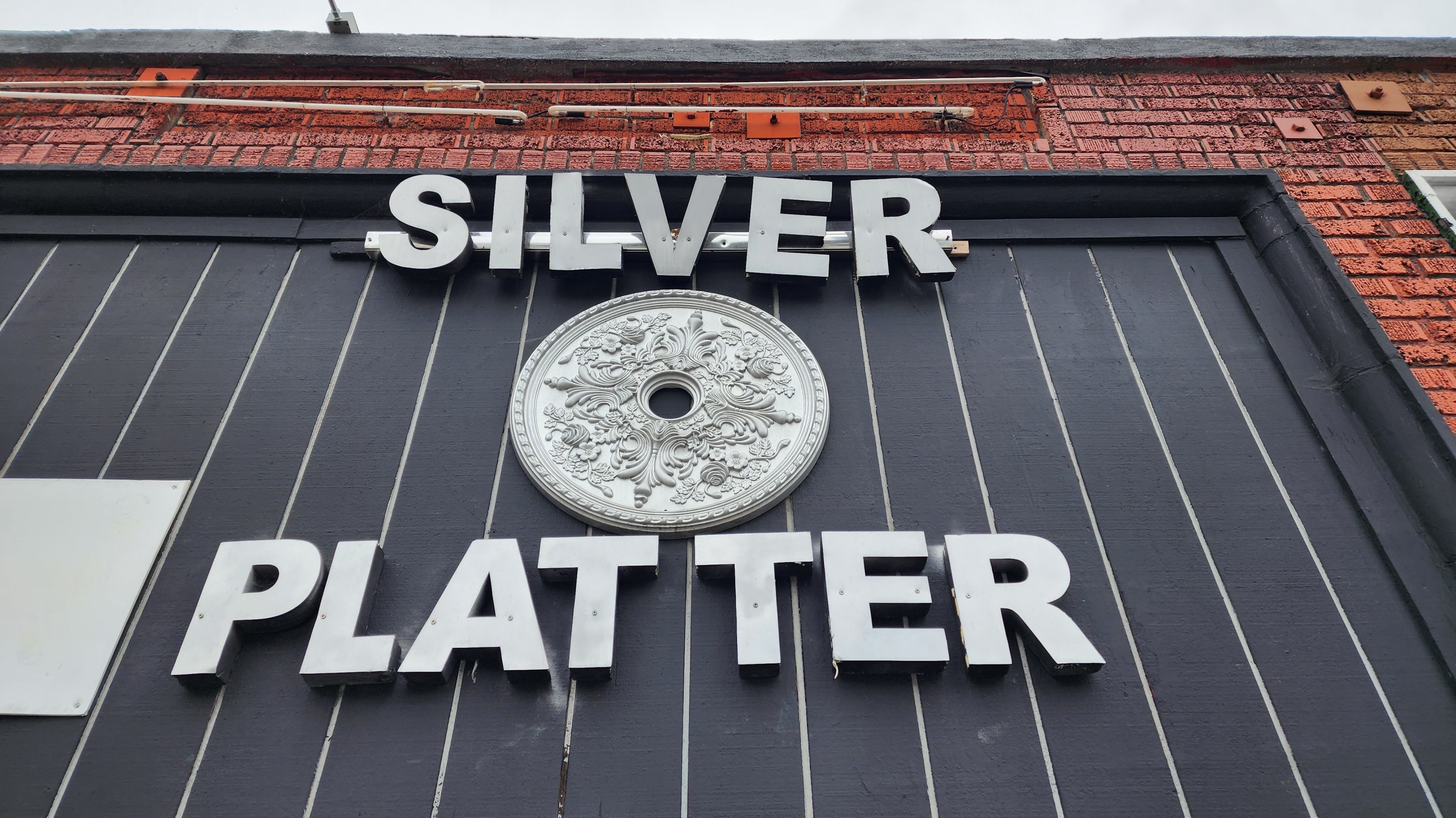 The words silver and platter with an emblem between them featured on the front of the Silver Platter on 7th Street.