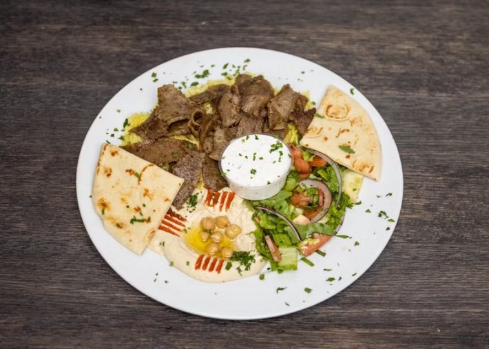 A plate of sliced beef shawarma with hummus and salad at Anwar's Kitchen in L.A.