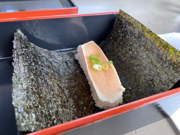 a piece of raw fish in a sheet of nori