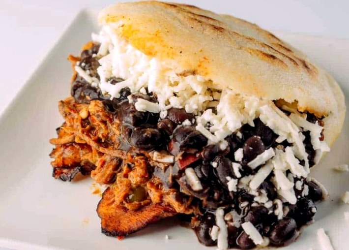 Arepa de pabellon with carne de res mechada, black beans, fried plantains, and queso blanco fresco.