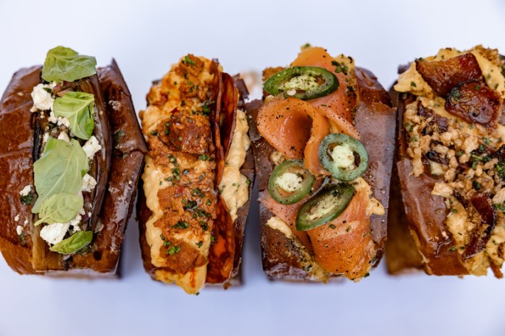 Four stuffed brioche sandos with smoked salmon, eggplant, and bacon and cheese.
