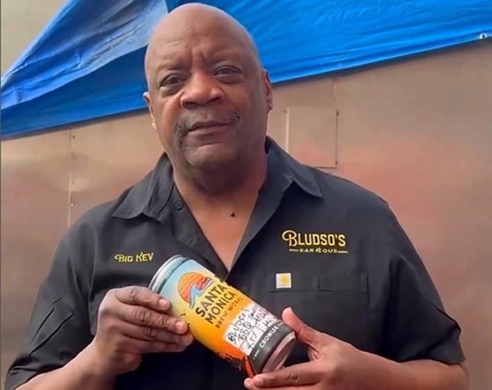 Pitmaster Kevin Bludso holding a yellow can of beer
