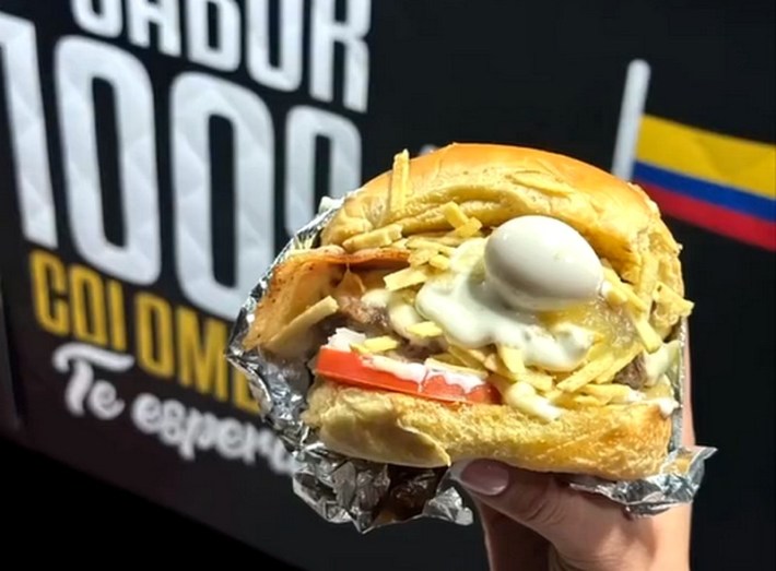 A Colombian hamburger with egg and cheese poking out.