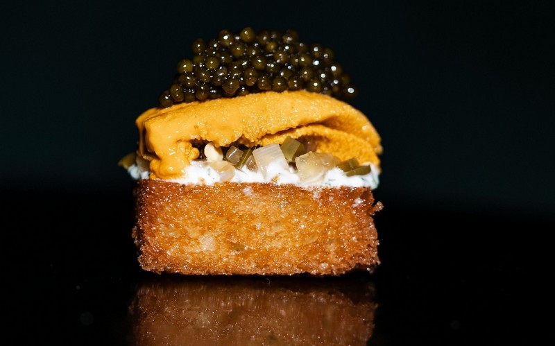 A piece of toast topped with uni and caviar