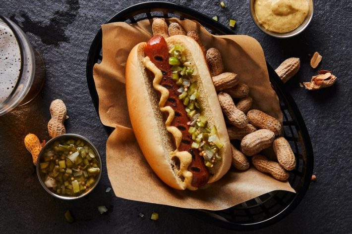 A vegan Dodger Dog with mustard and chopped jalapenos