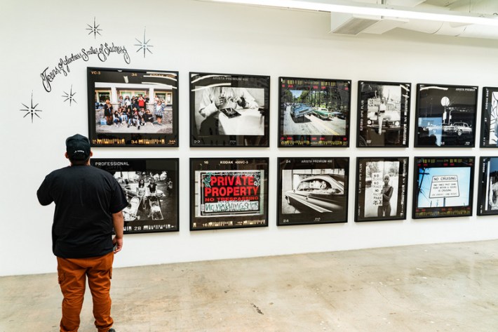 A guets looks at a wall of photos by Estevan Oriol at Beyond the Streets gallery in Los Angeles