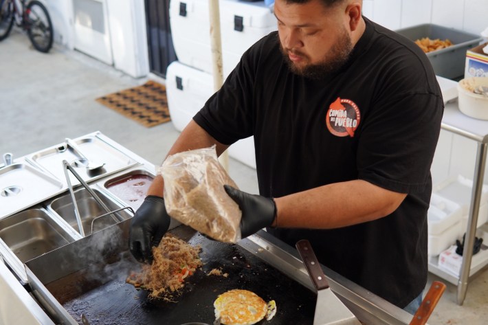 A chef sprinkles machca on his plancha