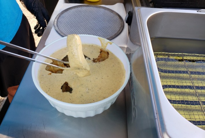 Fish being dipped in batter