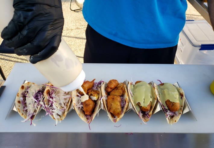 Razo putting his handmade sauces on the tacos at Razo's Fish Tacos.