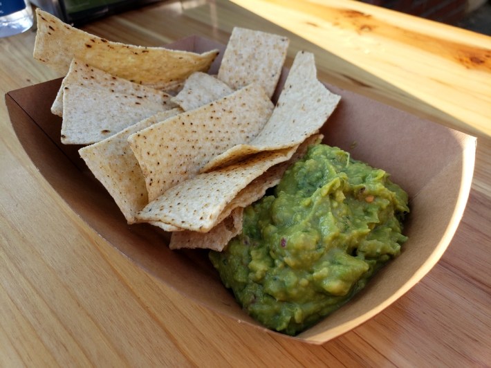 Guacamole with chips in a cardboard box