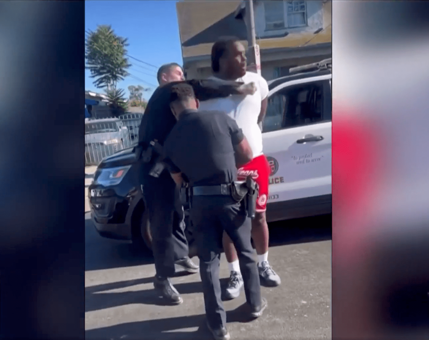 Screenshot of an unidentified LAPD officer punching a man in the face with their right fist.