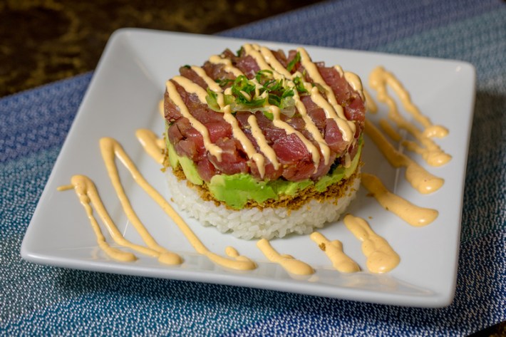 A poke tower with tuna, avocado, and white rice.