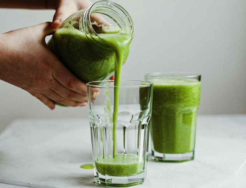 Green smoothies, mid-pour from a jar