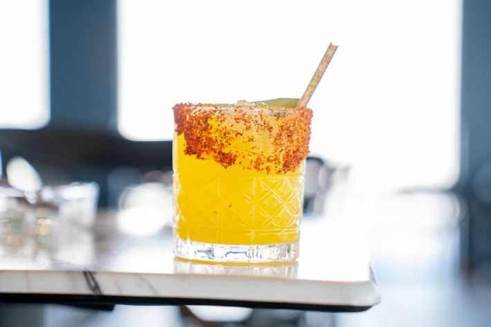 An orange THC cocktail with a cxhamoy-and-tajin rim at The Artist Tree