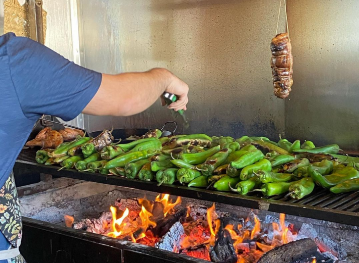 Chiles on the grill at Bacanora, with a trussed piece of meat over the grill