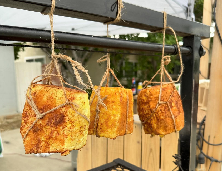 Trussed pineapples smoking over a grill