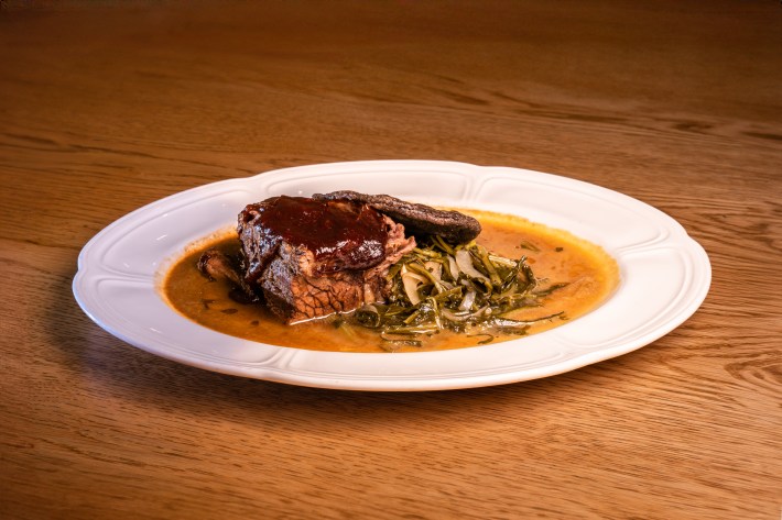 Braised bison with berry BBQ sauce, braised dandelion greens, and a blue corn cake.