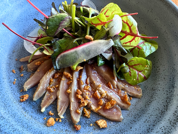 Chef Pyet DeSpain's duck ham: A smoked duck breast with duck skin chicharrón, hydro cress, and sorrel, orange and honey vinaigrette, and radish.