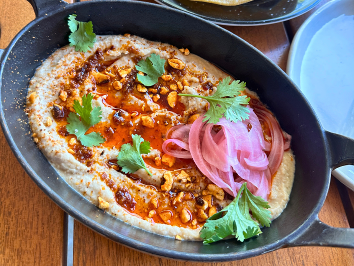 Smoked tepary bean dip with spiced corn nuts, pickled onion, and maple chili oil, and a corn tostada