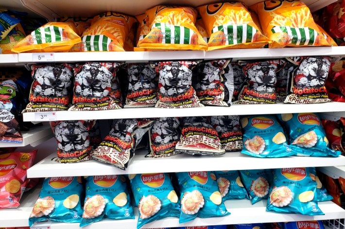 Shelves of Ssallop Lay's chips and spicy hotpot chips branded for Street Fighter character Zangief at Miniso, Santa Monica