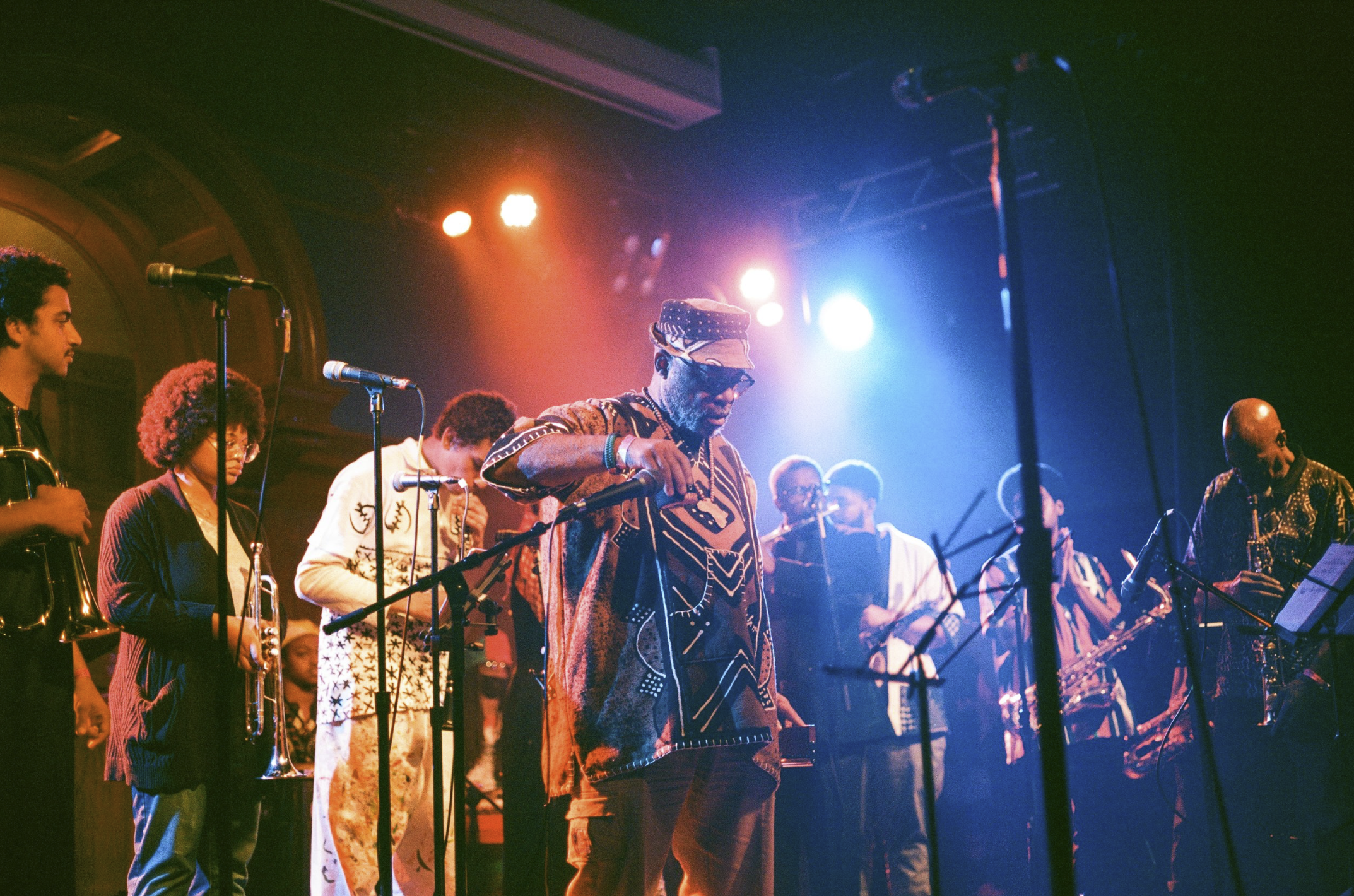 Members of Pan Afrikan Peoples Arkestra stand on stage under stage lights at the Lodge Room in Highland Park.