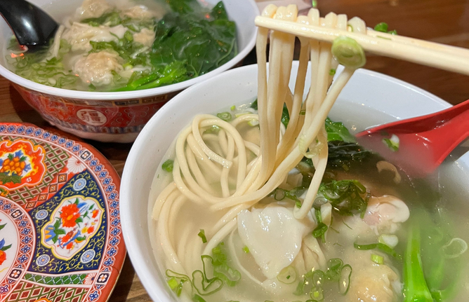 A brothy bowl of noodles with fish and scallions at Peking Tavern.