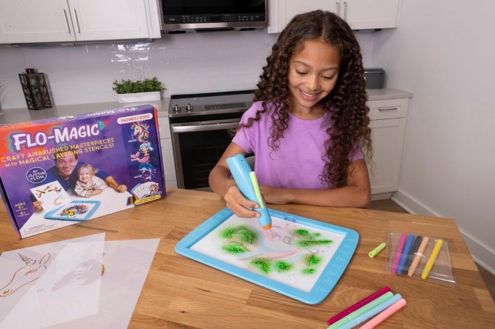 A girl works with FloMagic markers and stencils kit.