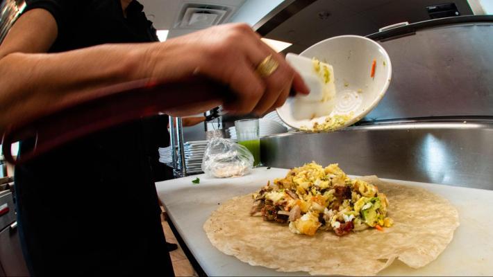 The making of Los Molcajetes' Salvi breakfast burrito .