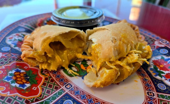 An empanada split openn with aji de gallina